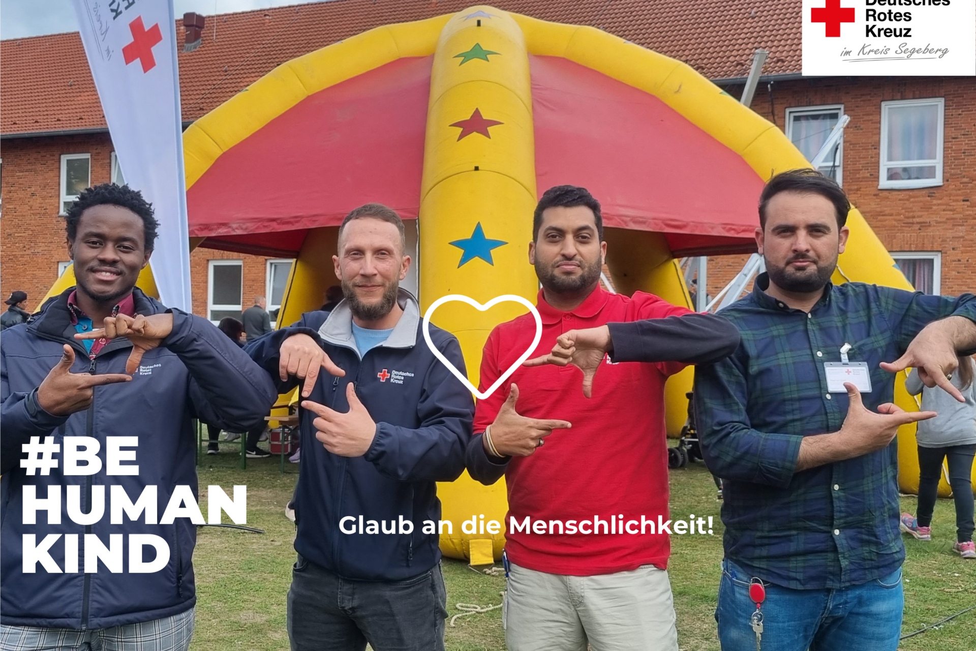 Foto von vier Männern auf einem DRK-Fest. Auf dem Bild steht der Text "Glaub an die Menschlichkeit!" und "#BEHUMANKIND". Zwischen den Männern ist ein weißes Herz gezeichnet.