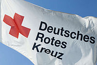 Weiße Flagge mit dem roten Kreuz und der Aufschrift "Deutsches Rotes Kreuz".