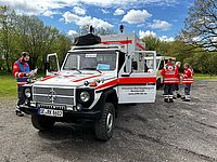 Dienstwagen der DRK Segeberg Bereitschaf, mit vier Personen in DRK-Kleidung im Hintergrund.
