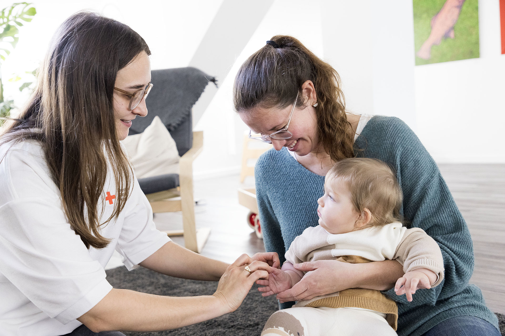 Mutter mit ihrem Baby und Mitarbeiterin vom DRK.