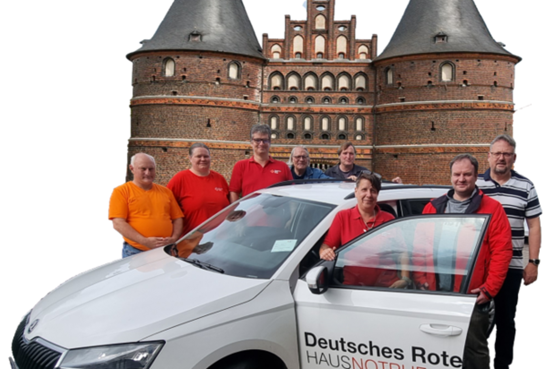 Foto des achtköpfigen Hausnotruf-Teams des DRK Kreis Segeberg und Steinburg. Die Teammitglieder stehen um ein DRK Auto herum.