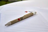 DRK Stift liegt auf einem leeren Schreibblock mit dem DRK Logo.