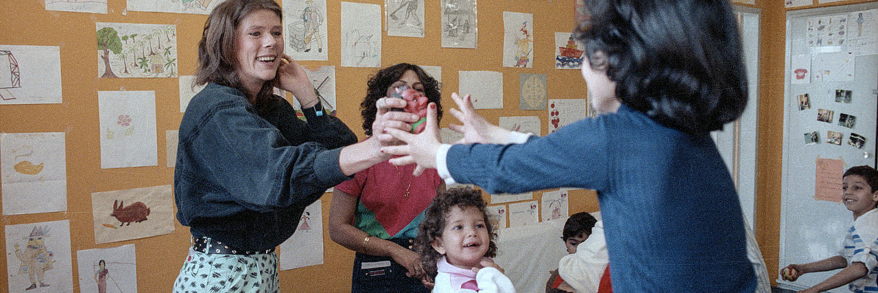 Betreuung von Asylbewerbern in Berlin. Eine Frau spielt mit Kindern.